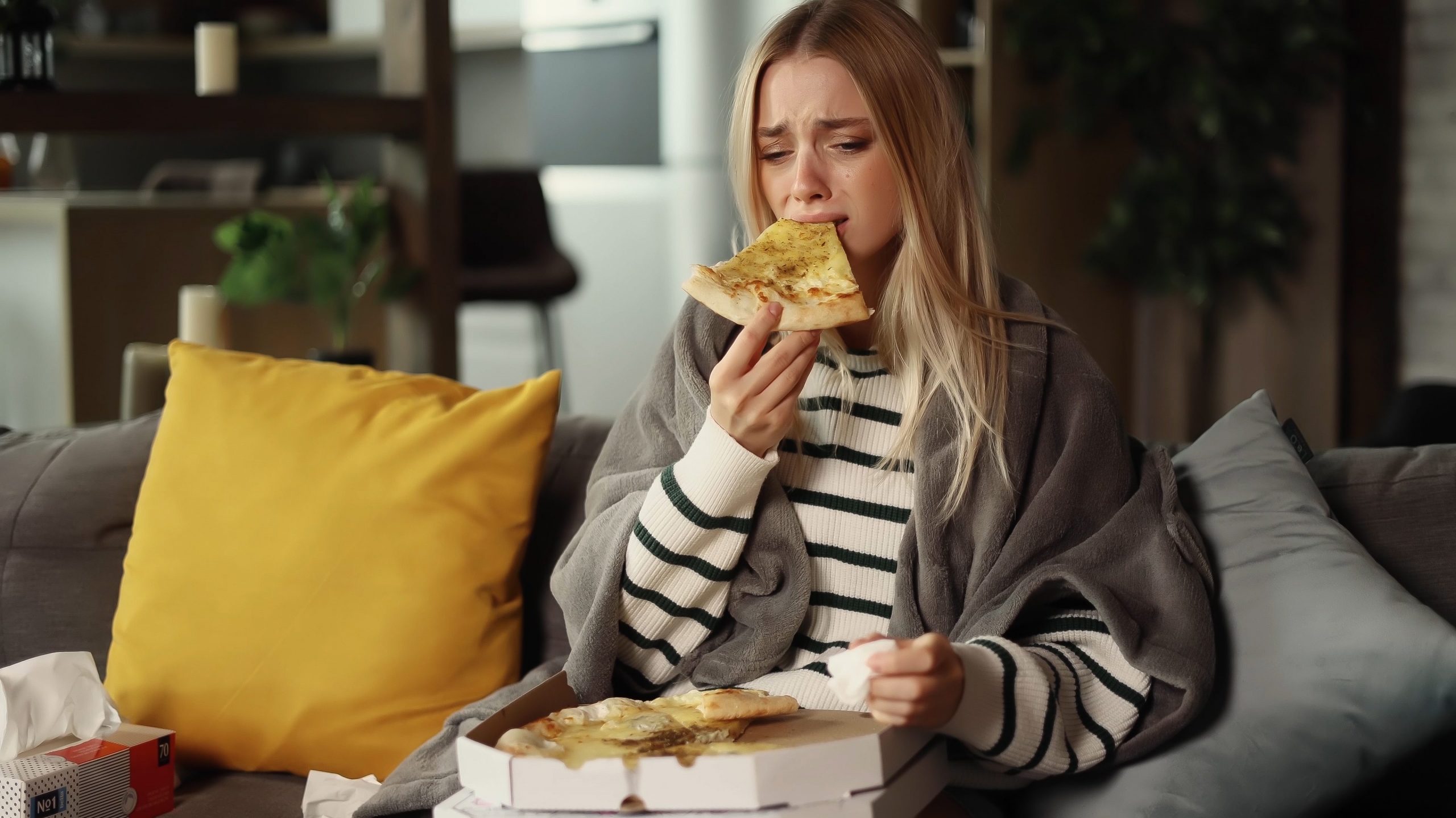 Mulher com depressão, aliviando a tristeza com comida. 